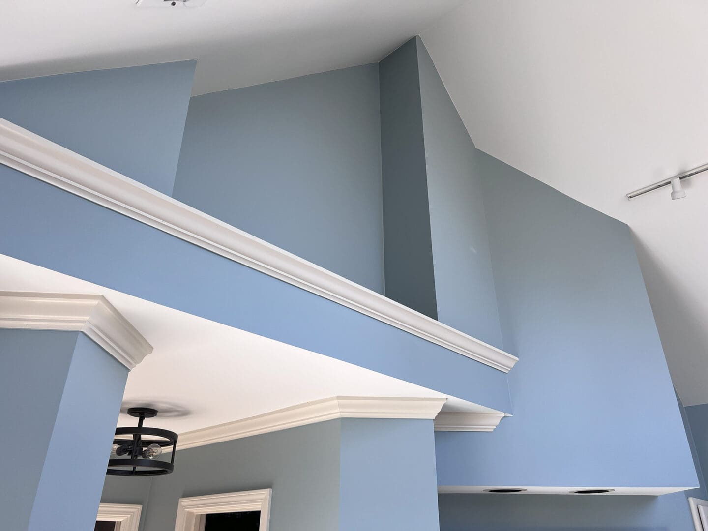A blue wall with white trim and ceiling.