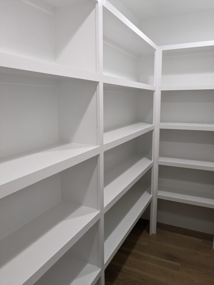 A white shelf in the middle of a room.